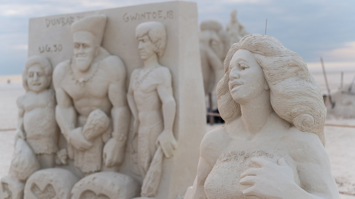 Uma intrincada escultura de areia que mostra uma família primitiva como parte do Sanding Ovations, um festival anual de escultura em areia na Ilha do Tesouro.