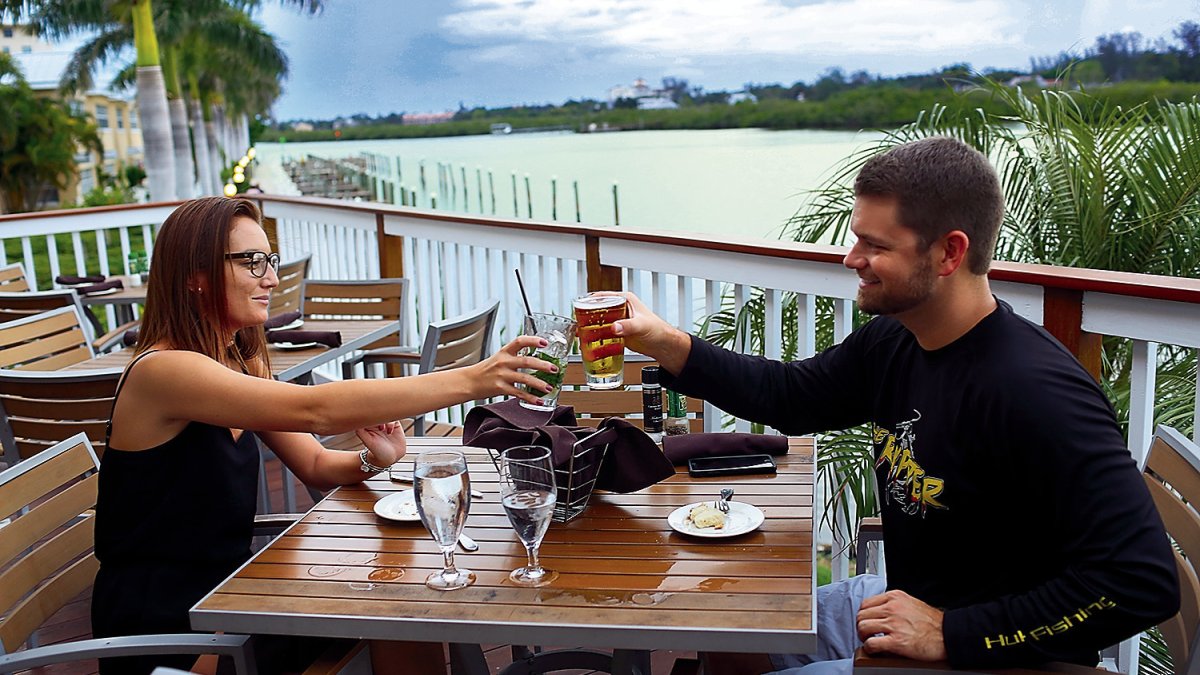 A couple toasts at a outdoor table at Salt Rock Grill