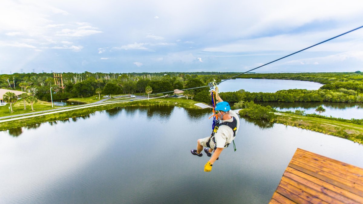 A man descends a zip line at Empower Adventures