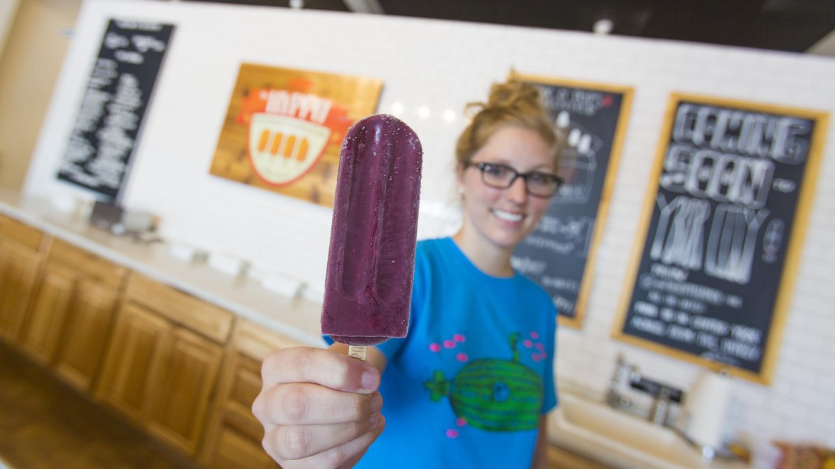 A woman holds up a popsicle at Hyppo gourmet ice pops