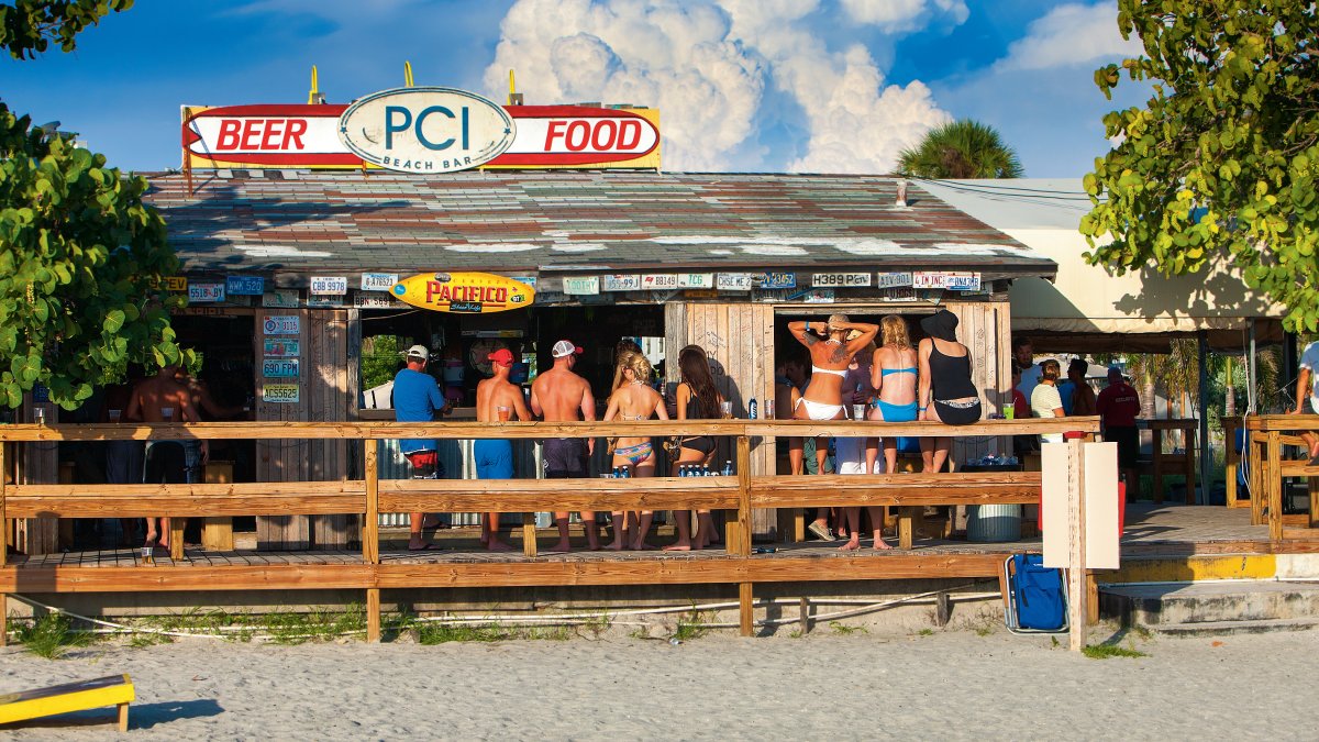 Außenaufnahme von Menschen, die in der Postcard Inn Beach Bar & Snack Shack in St. Pete Beach trinken