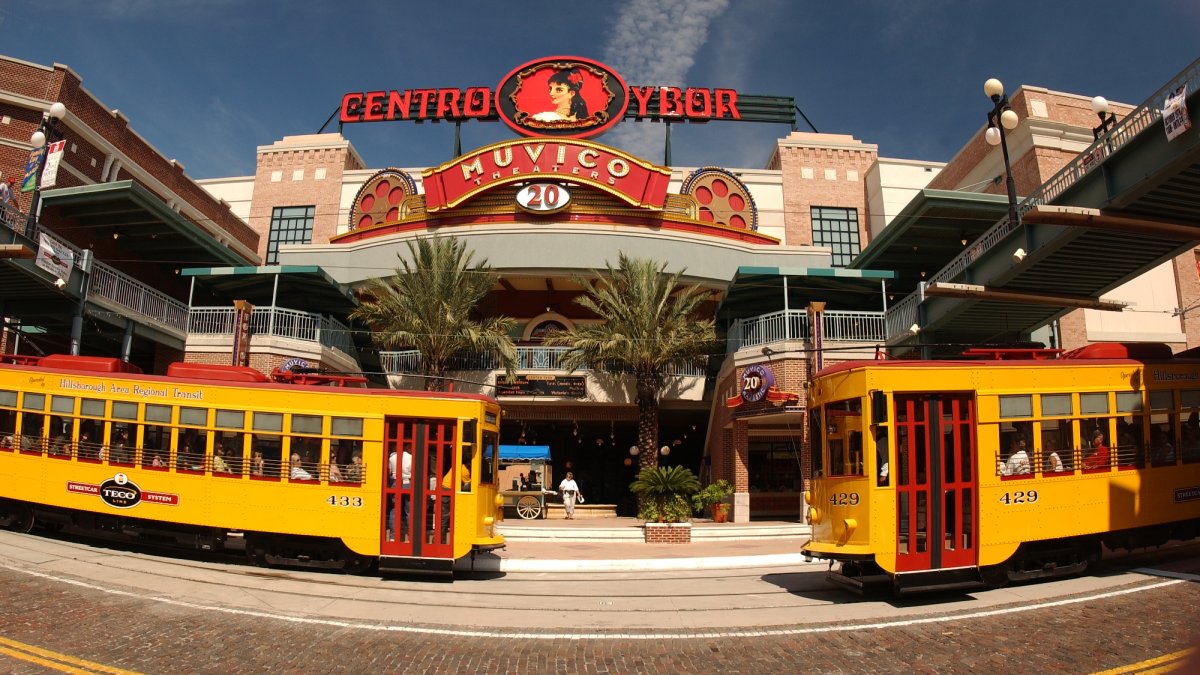 Two trolleys parked in front of a movie theater in Ybor City