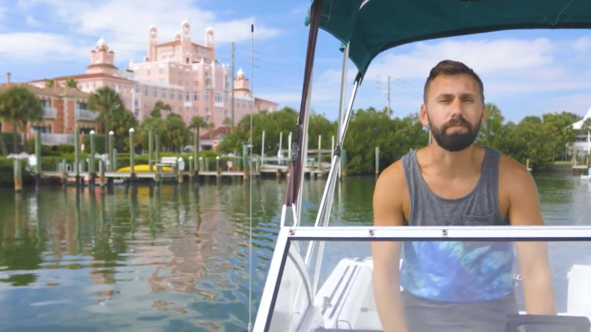 A man riding a boat off of intracoastal waters of St. Pete. Vinoy Resort can be seen at a distance.