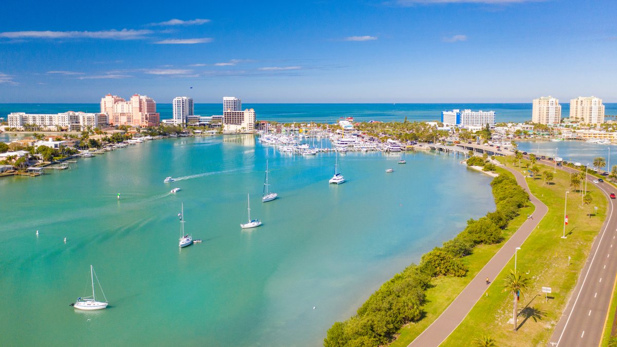 Una vista aérea de Clearwater Marina y Memorial Causeway que muestra aguas verdes y cielo azul brillante.