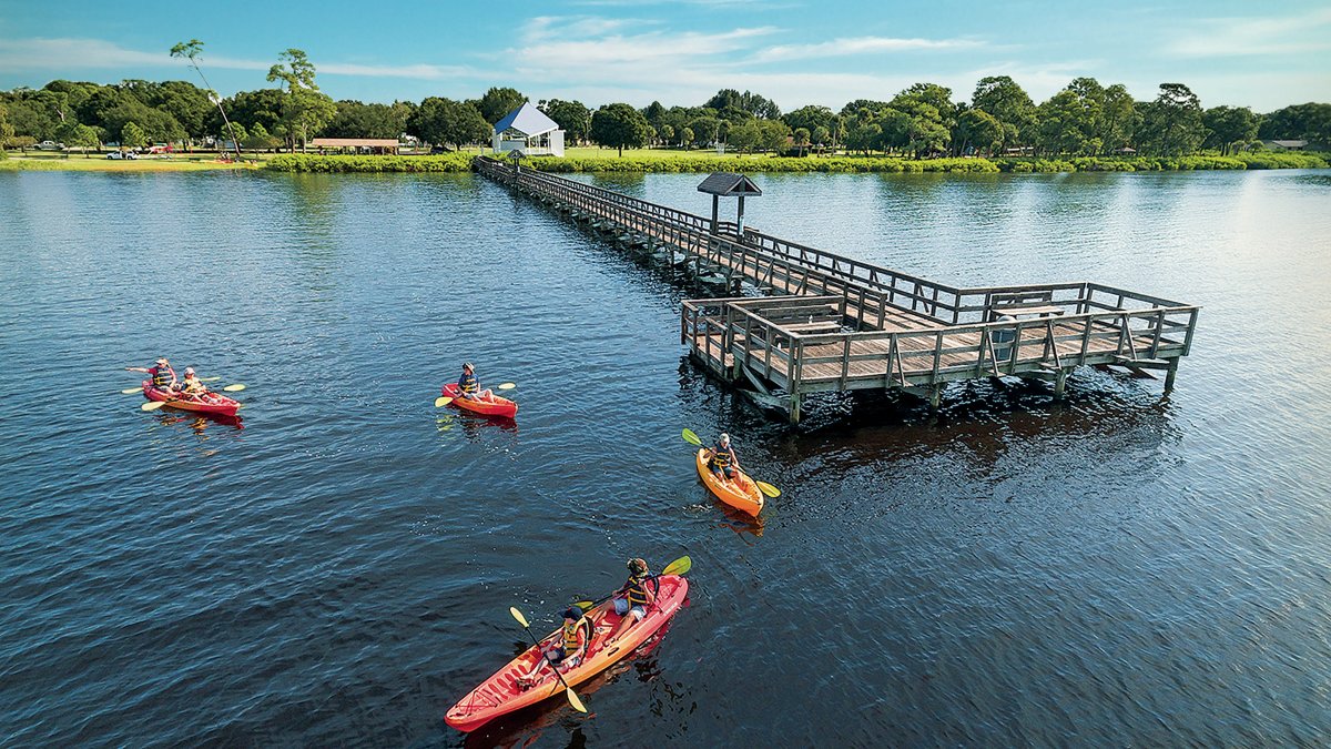 Um grupo de pessoas andando de caiaque perto do cais Oldsmar no RE Olds Park.