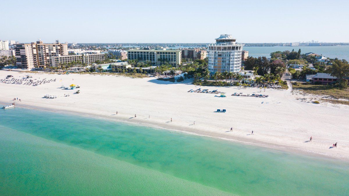 Vista aérea das águas verde-esmeralda de St. Pete Beach com o Bellwether Beach Resort ao fundo