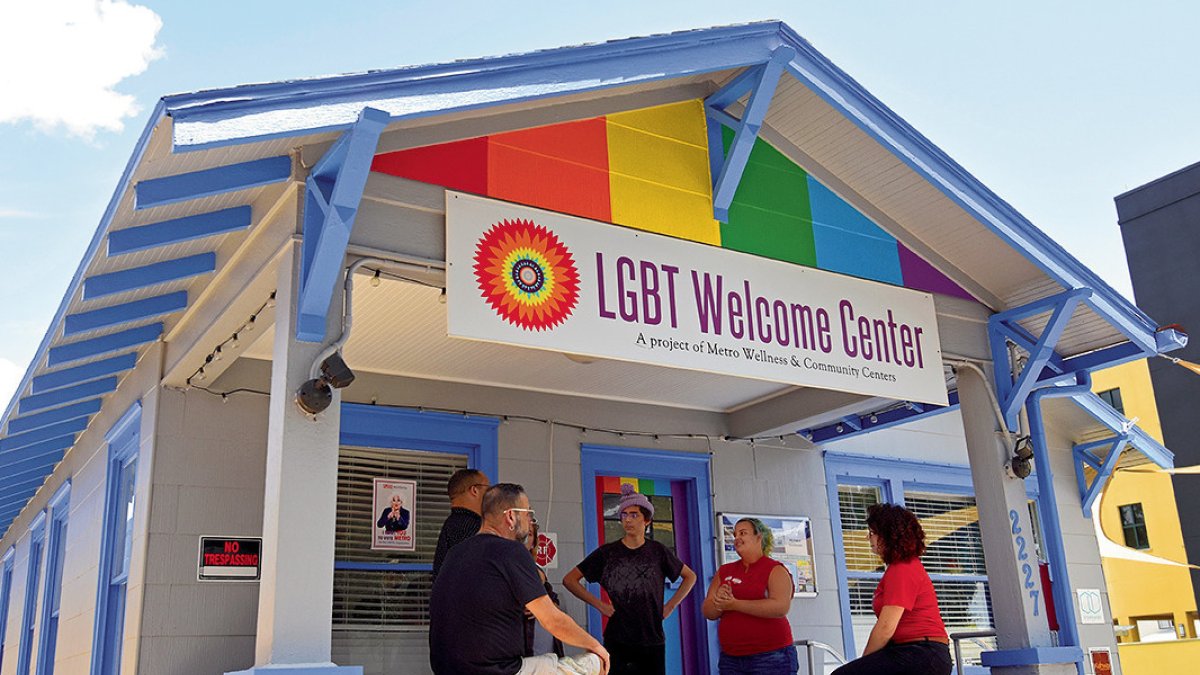 A group of people seating in front of the LGBTQ+ Welcome Center in St. Petersburg