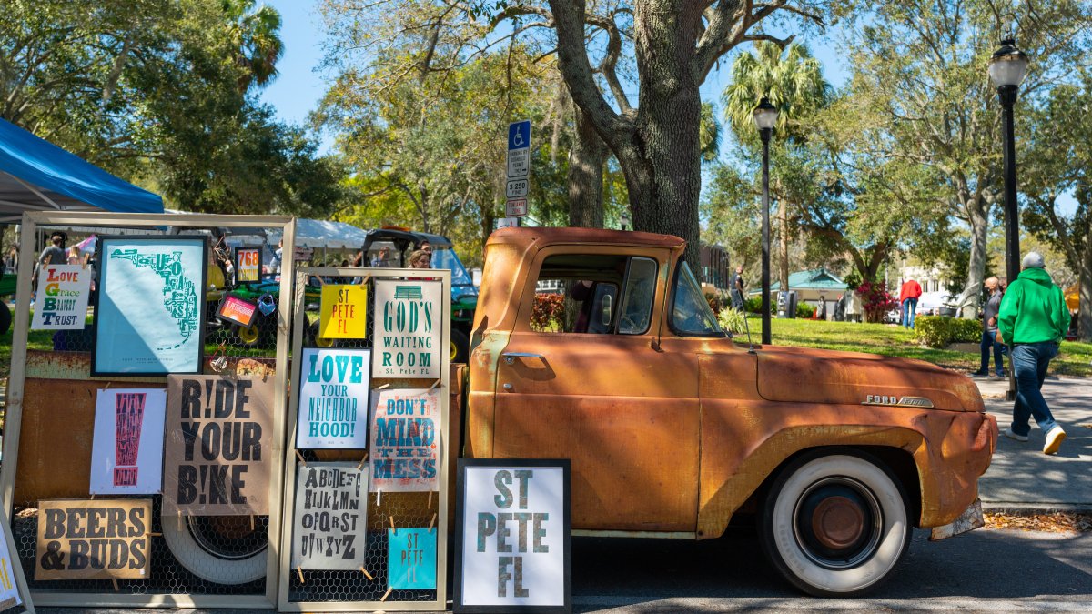 An old car surrounded by art posters.