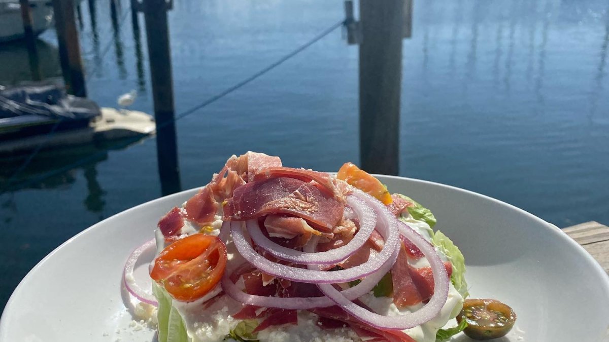 A plate of salad with a view for the marina.