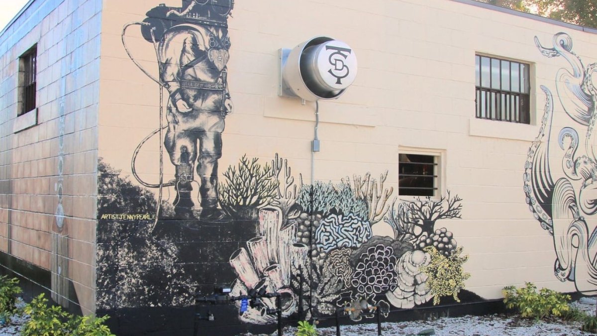 A sponge diver painted in the wall of the Tarpon Springs Distillery storefront