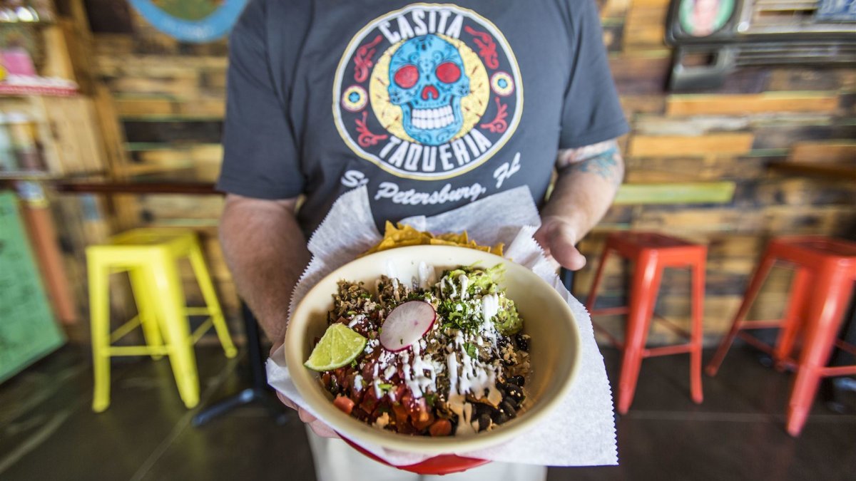 A waiter holds up a taco bowl from Casita Taqueria in downtown St. Pete