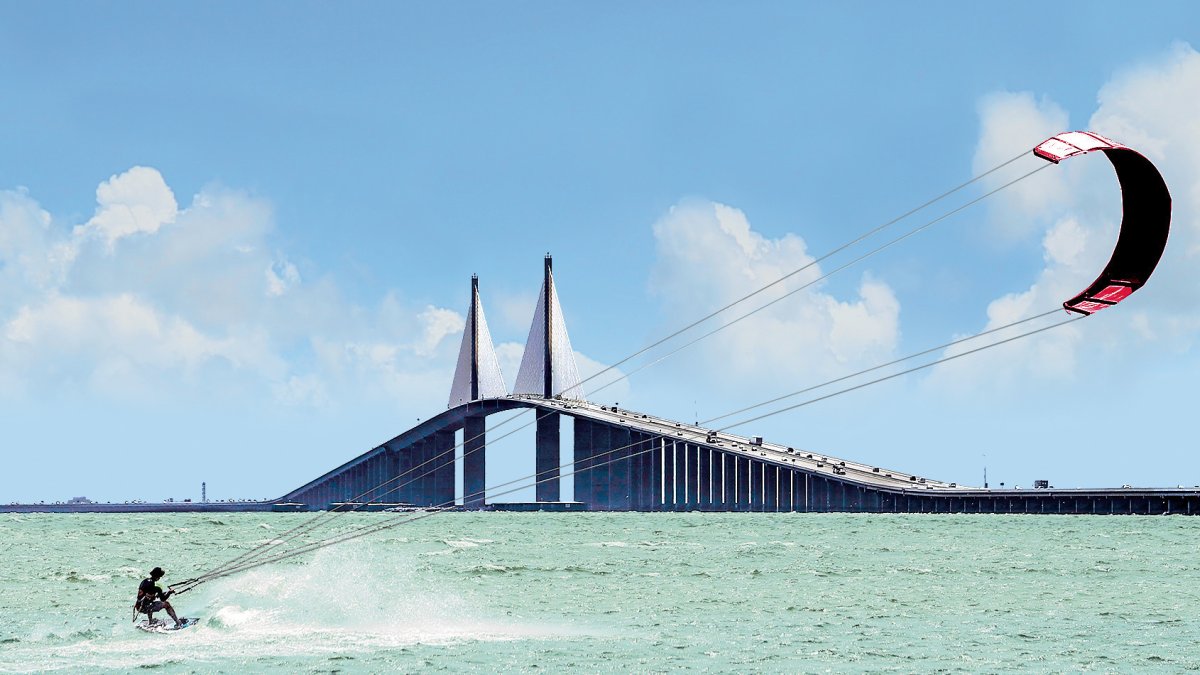 A man kiteboards at the Skyway Bridge