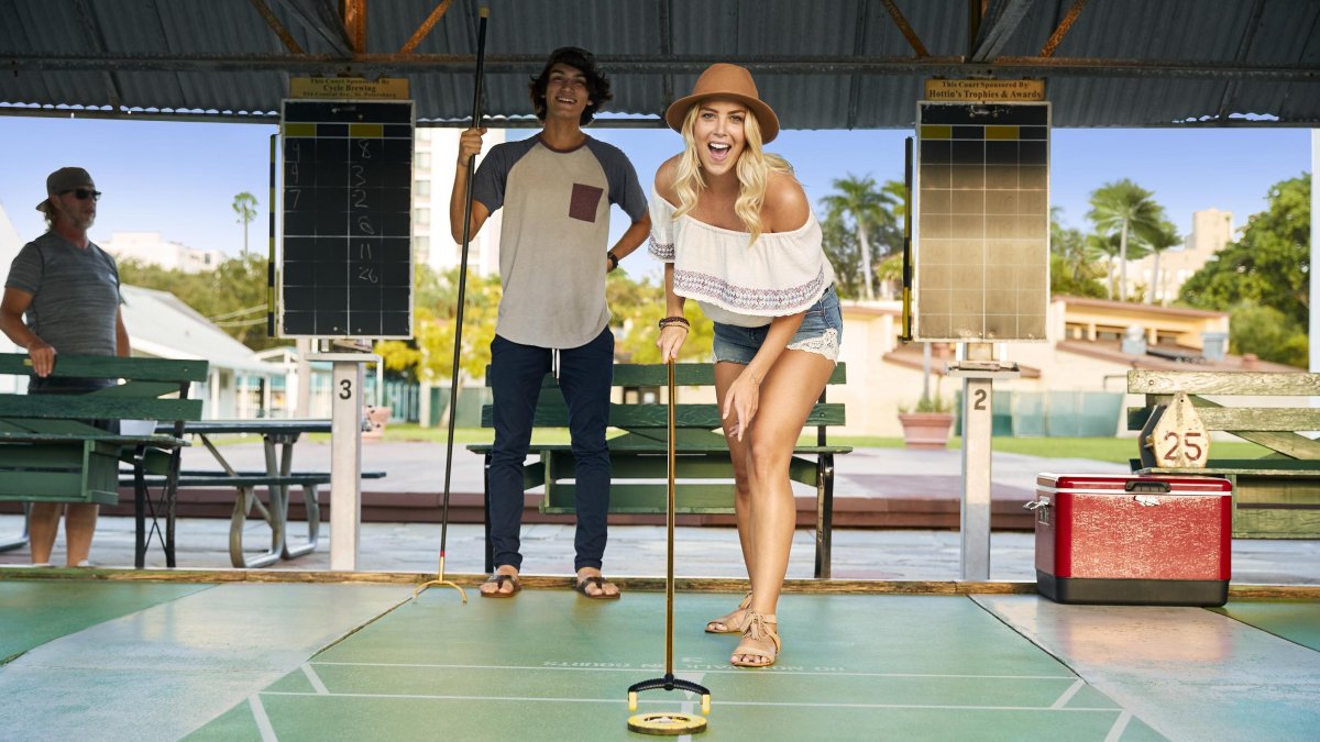 A woman pushes a disc on a shuffleboard at the St. Pete Shuffleboard Club