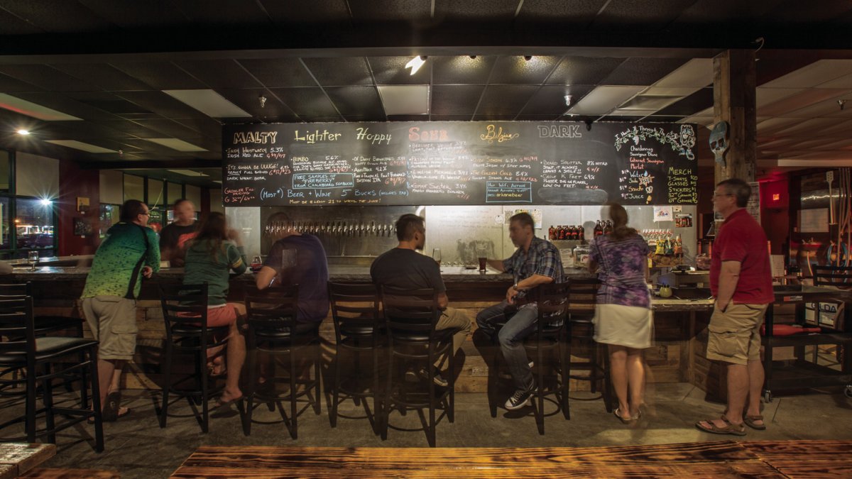 Several people enjoying drinks inside Arkane Aleworks.