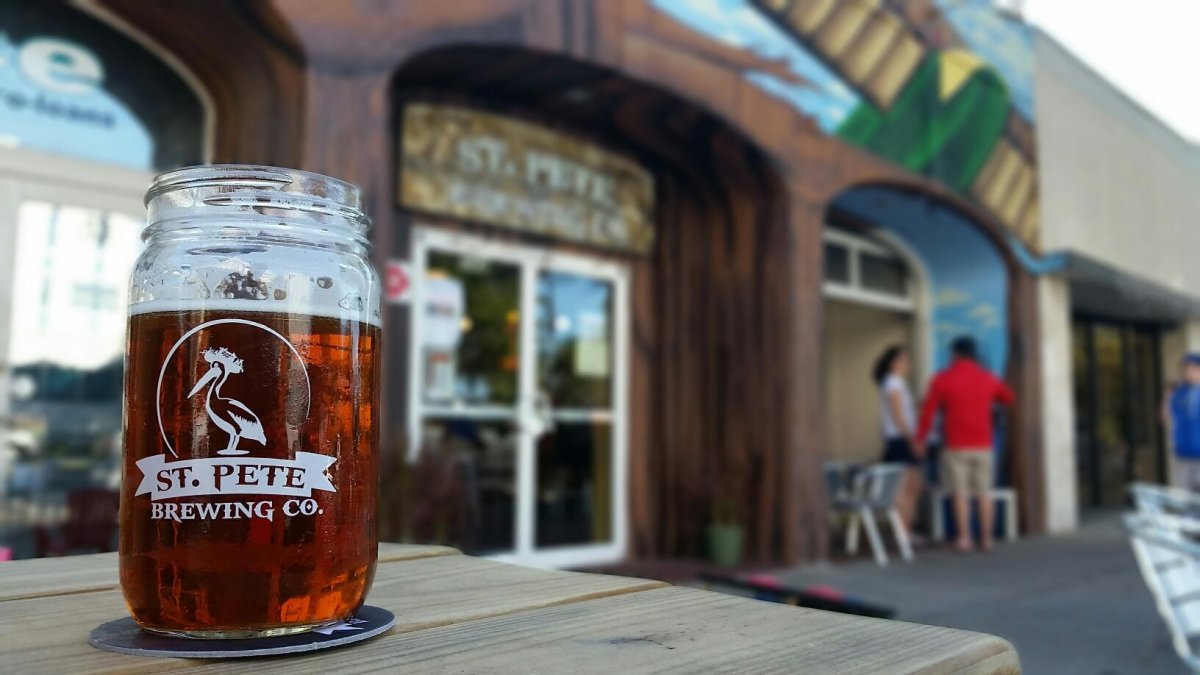 A beer glass on top of a table outside of St. Pete Brewing Co.