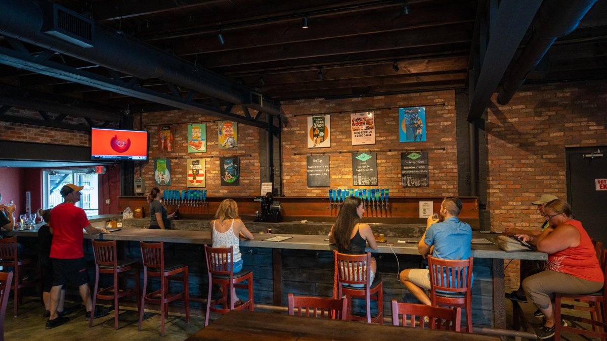 Several people enjoying beer inside the brick walls at Bayboro Brewing.