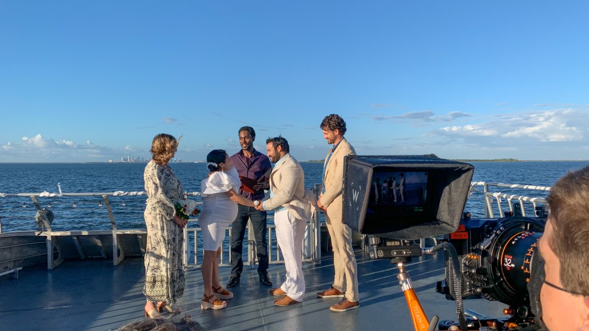 A man and a woman get married on a boat with a view of the water.