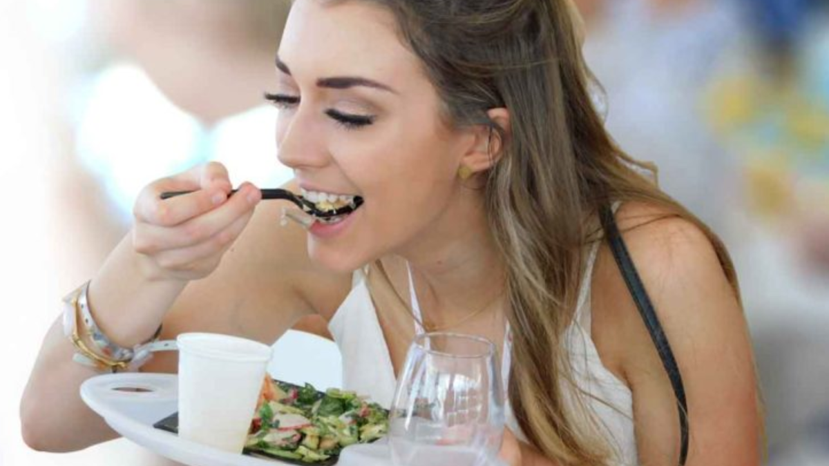 A woman eats a salad at Savor The Burg