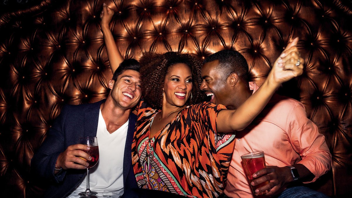 Three people dancing in a booth at Tryst Gastro Lounge