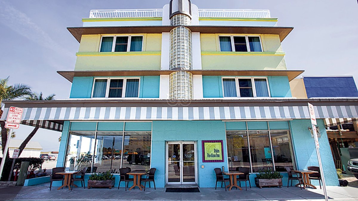 An exterior shot of a hotel that is blue and yellow.