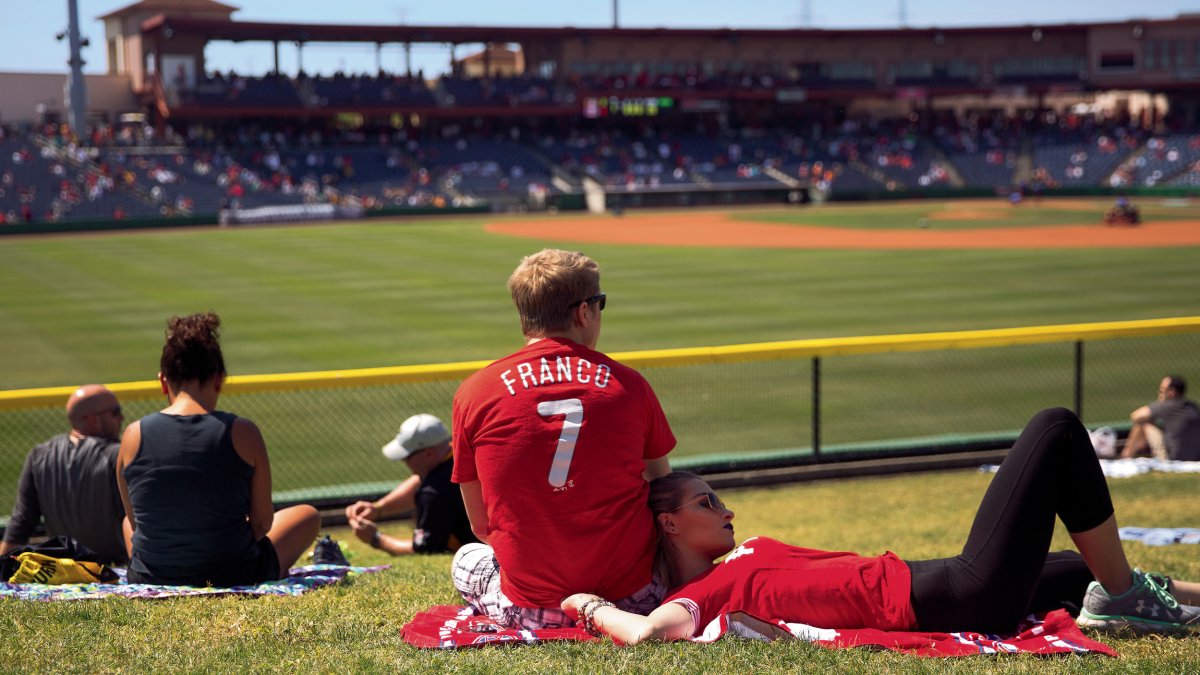 A couple rests on the field and watches the Phillies Spring Training Games