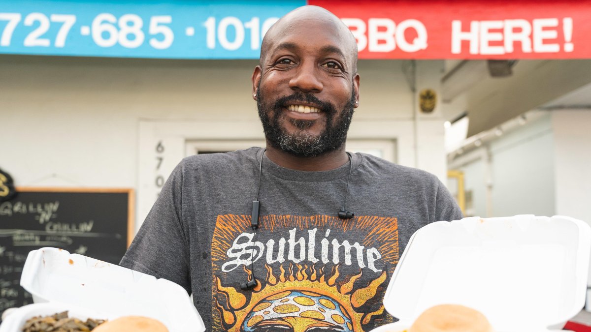 A barbecue restaurant owner holds up some of his creations