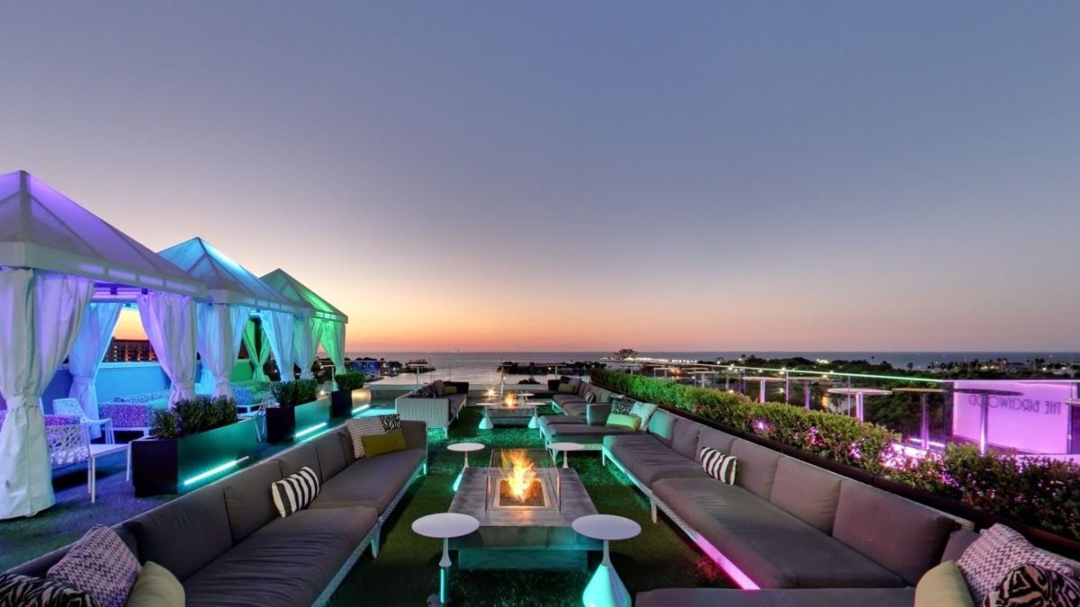 Evening image at The Birchwood Canopy Rooftop bar with cabanas and bay views