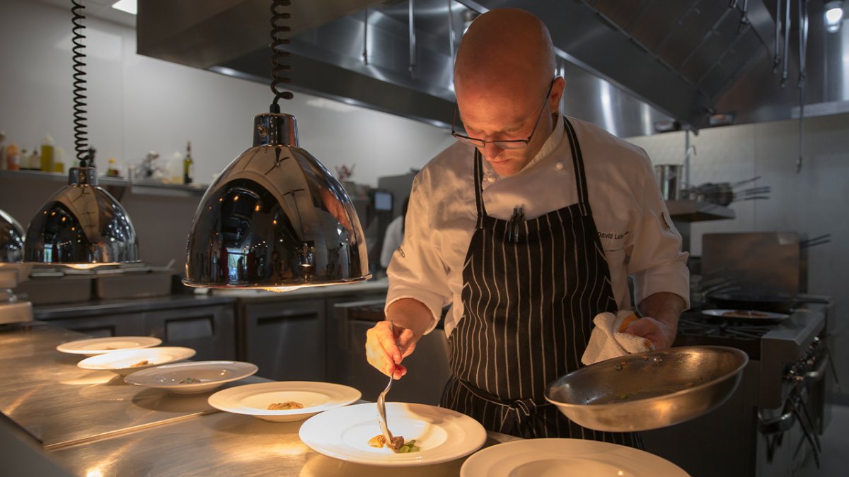 A chef preparing a plate at a restaurant.