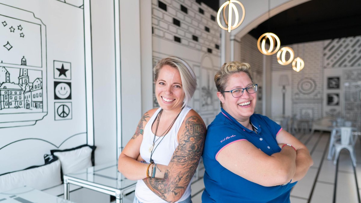 Two restaurant owners smiling inside of their art-inspired 2D Café in St. Pete.