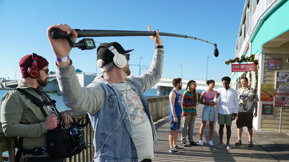 Television crew filming a scene of the show Life's Rewards on the boardwalk in John's Pass on a sunny Florida day.