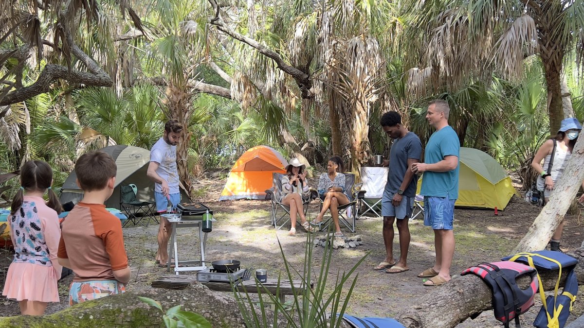 Behind the scenes of the cast and crew of Life's Rewards filming a camping scene in Fort De Soto Park, featuring tents, food and lifejackets.