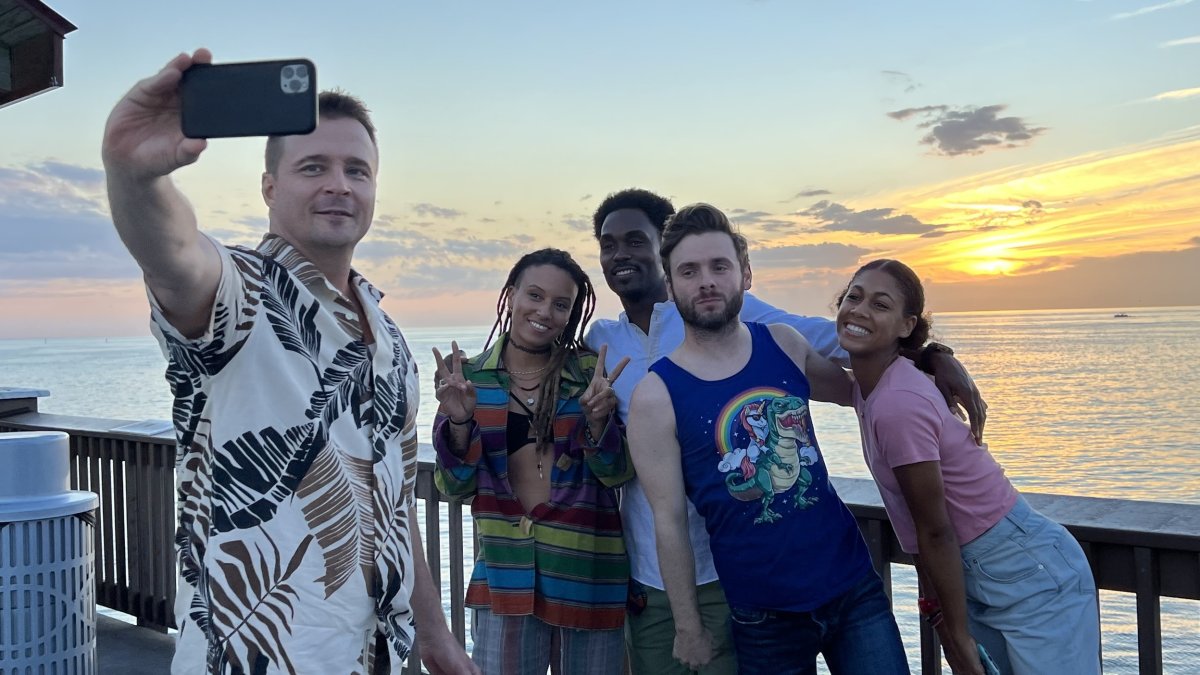 Five cast members of the series Life's Rewards pose for a selfie with the pink and yellow sunset at Pier 60 in Clearwater Beach.