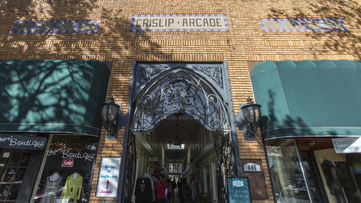 Outside shot of the Crislip Arcade featuring brown brick walls and green building shades. 