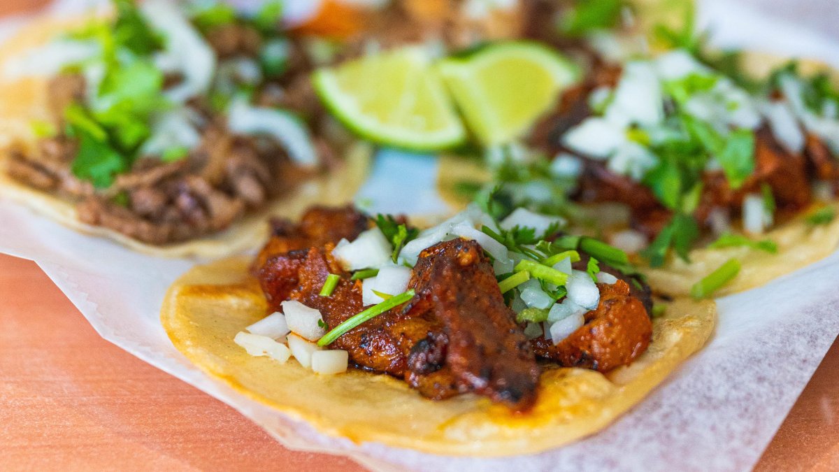 a plate of al pastor tacos with lime slices at El Huarache Veloz in Pinellas Park