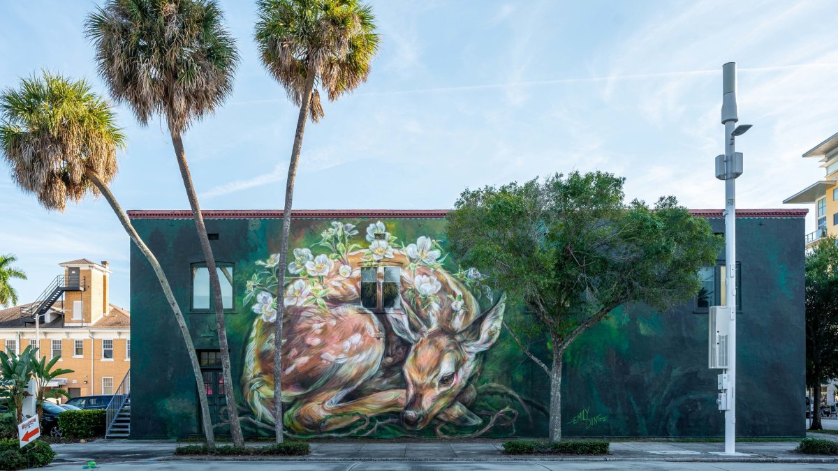 A building with a mural of a sleeping fawn on its walls.