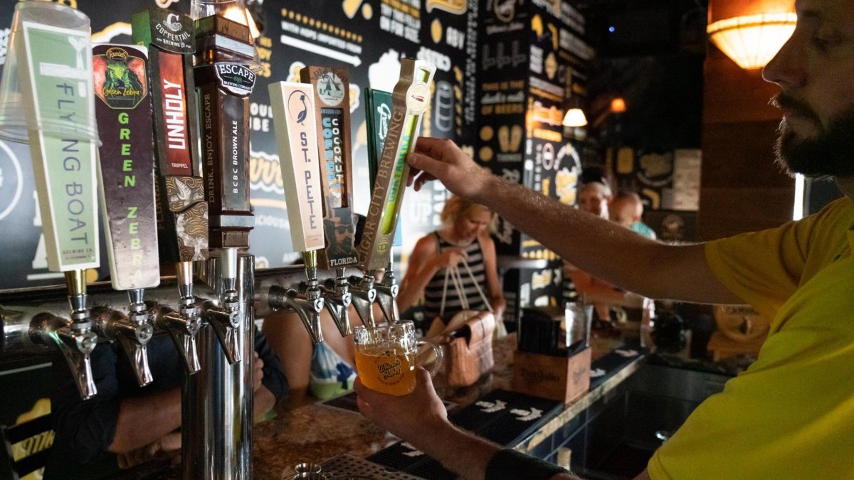 Man pouring a glass of draft beer for a customer at Where's Jubes Australian brewery in St. Pete.