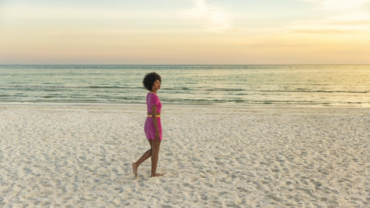 A woman walks by herself on the beach