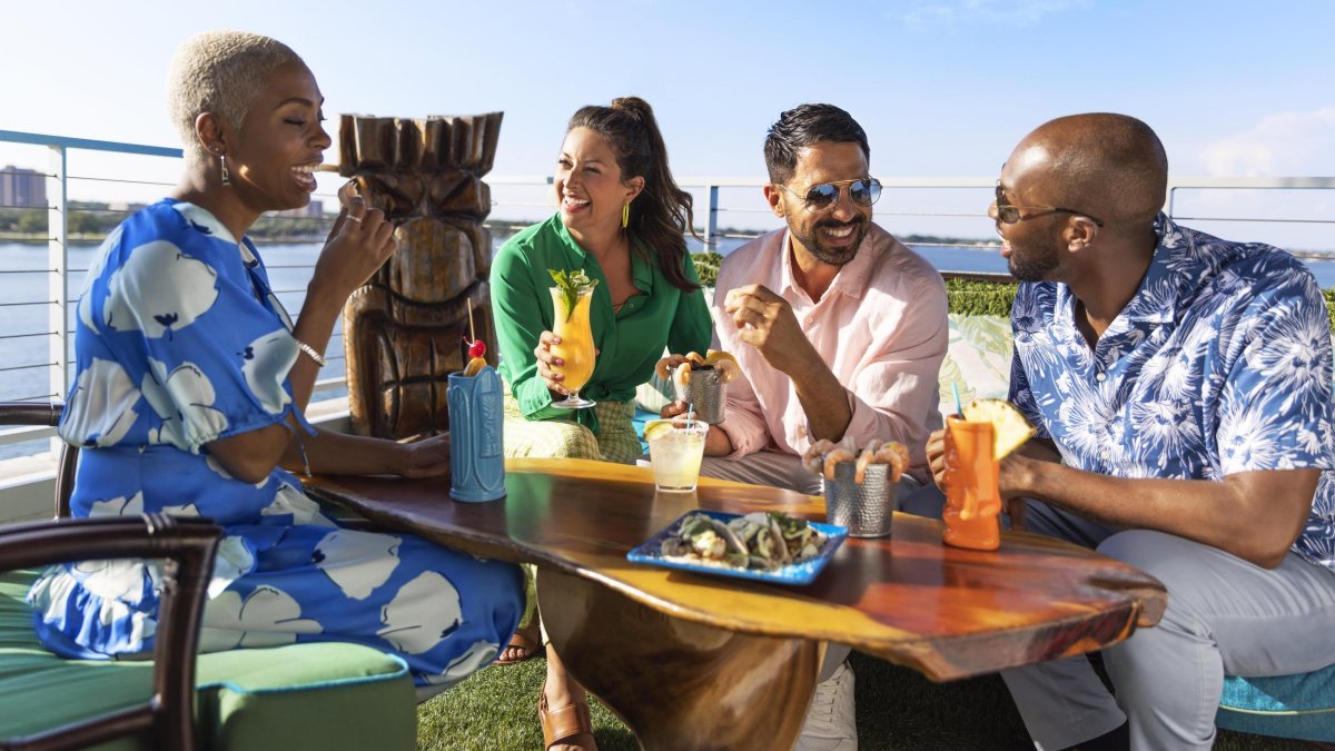 Zwei Paare genießen Getränke und Essen im Pier Teaki am St. Pete Pier.