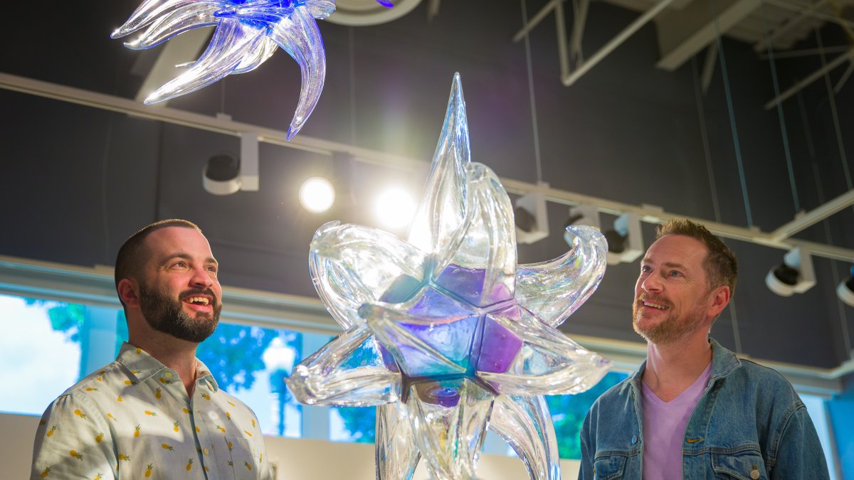 A gay couple looks at glass art at the Imagine Museum.