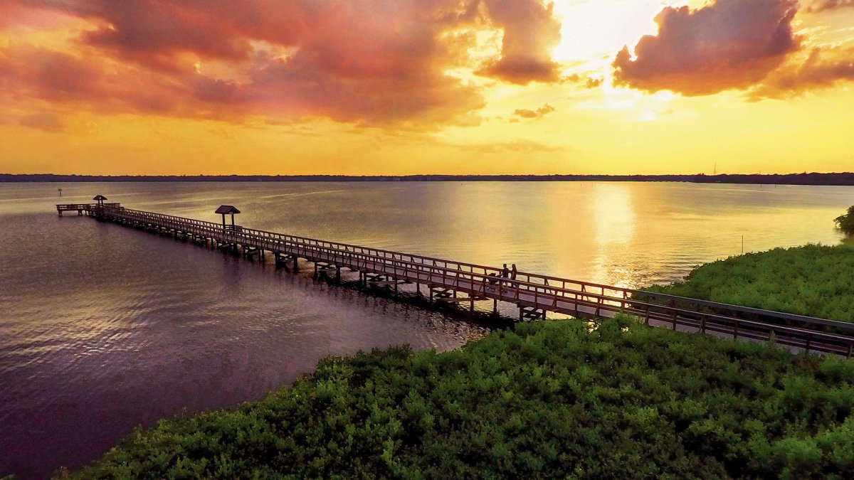 The sun sets over the fishing pier at R.E. Olds Park.