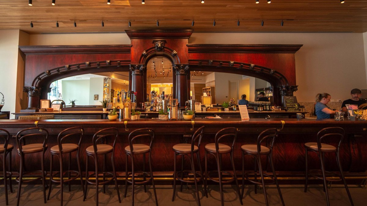 The interior of the Canyon Cafe with a dark-wood bar and metal chairs