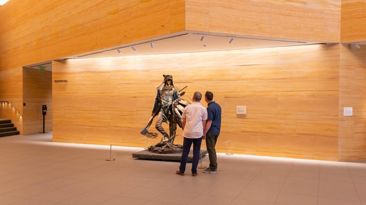 A couple looks at a sculpture in the airy lobby of the James Museum.