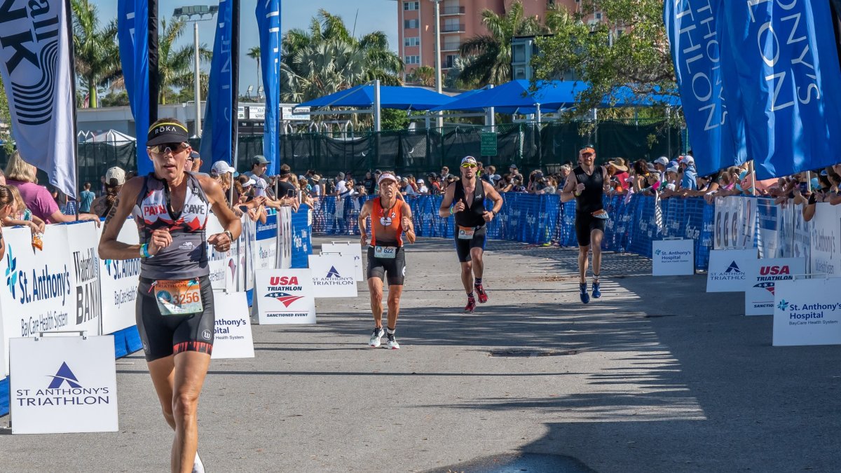 Four racers running outside during the day in the St. Anthony's Triathlon competition.