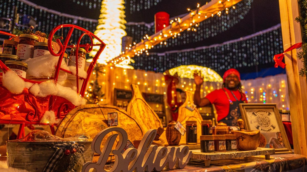 Gold and red holiday display with Believe sign and waving man