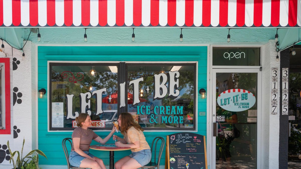 two women eat ice cream at a small table outside Let It Be Ice Cream in Gulfport