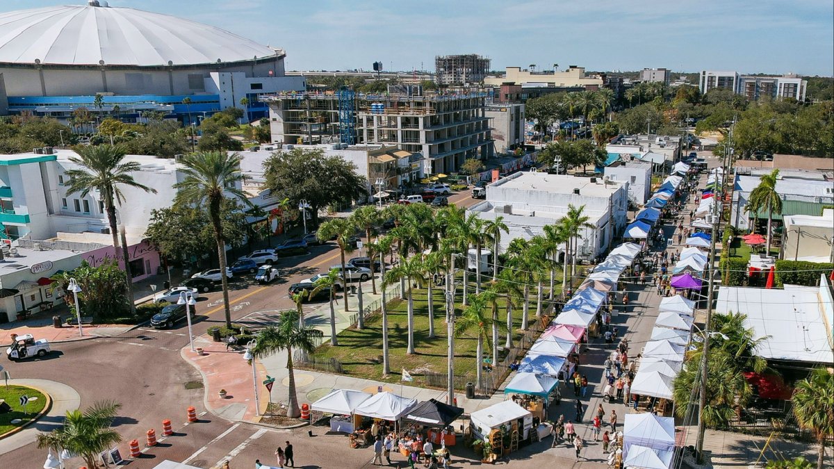 Aerial photo of the Mezzo Market in downtown St. Pete featuring a blue sky, Tropicana Field and dozens of market tents lined up.