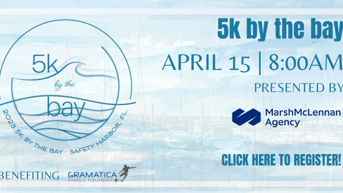 5K by the Bay racing event poster featuring a blue background and the ocean.