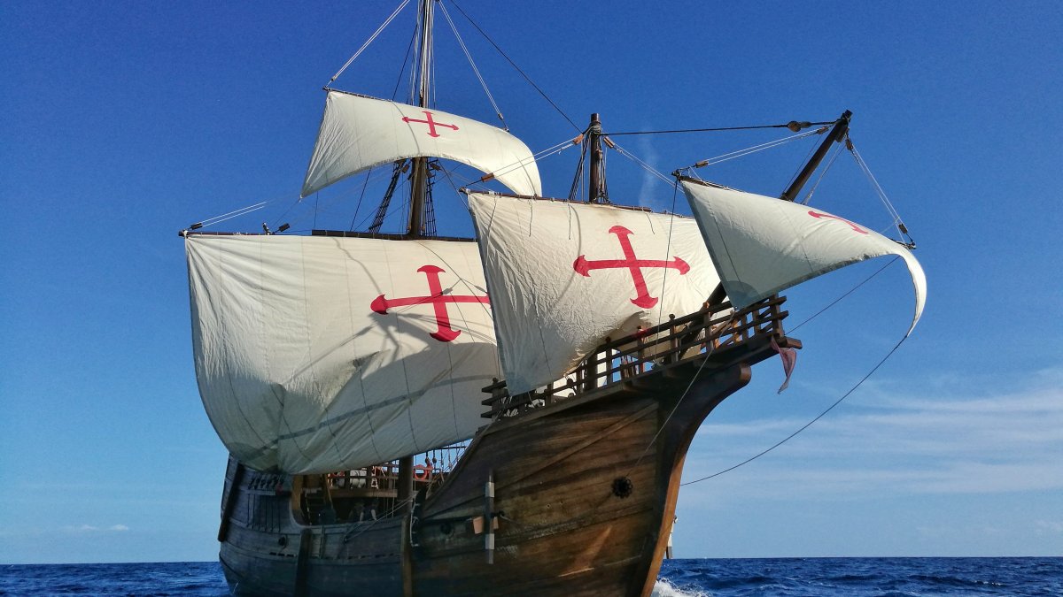 A tall ship with billowing white sails