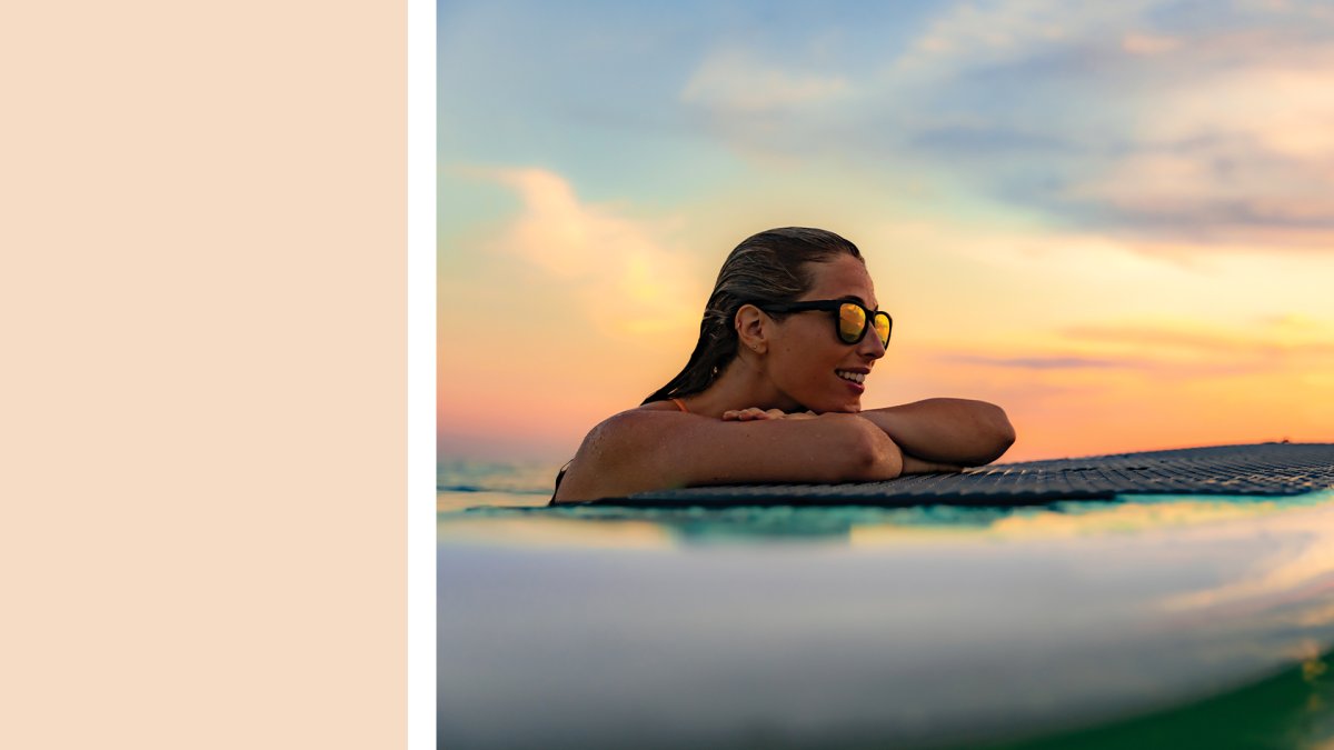 a cream color block next to a lady on a paddleboard watching the sunset