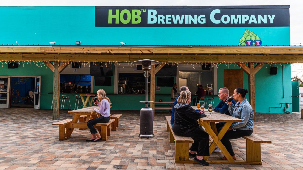 People sit and drink at picnic tables outside the HOB Brewing Co.